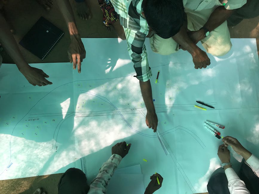 Group planning road design with drawings and tools outdoors.